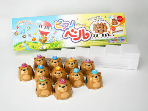 子供向け知育玩具の化粧箱　商品のベルと小箱を箱から出した様子