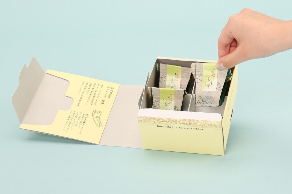 あきたこまちの香里 N式化粧箱。縦に商品を並べた仕切り付き。お菓子を取り出す様子